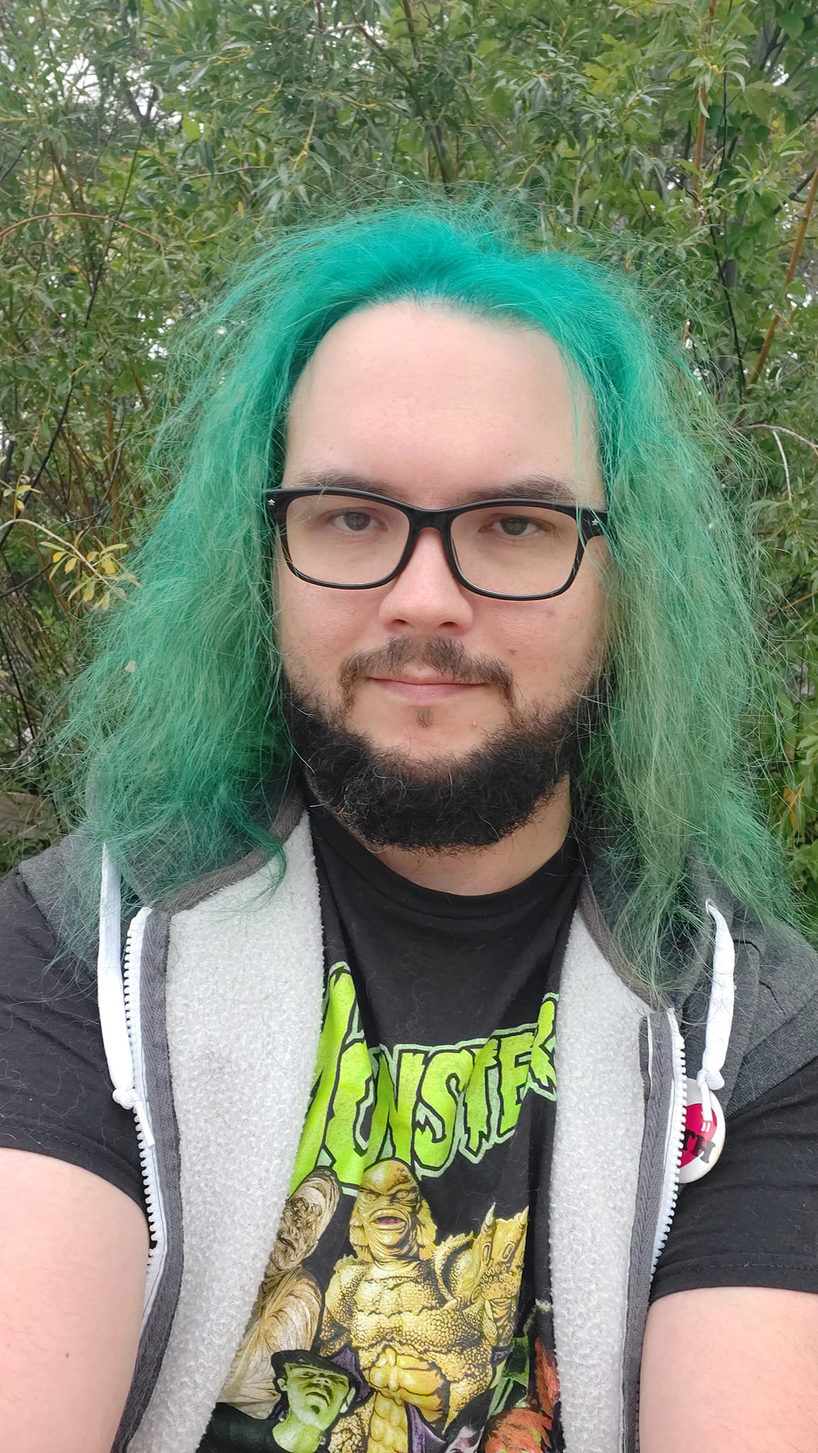 A man with green hair stands outside at a boulder breakwater, photo 5